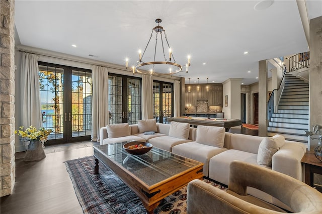 living room featuring french doors, an inviting chandelier, light hardwood / wood-style floors, and pool table