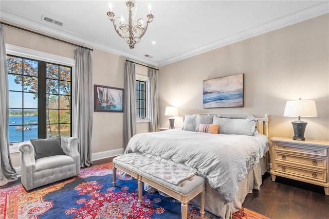 bedroom featuring a chandelier, a water view, crown molding, and dark wood-type flooring