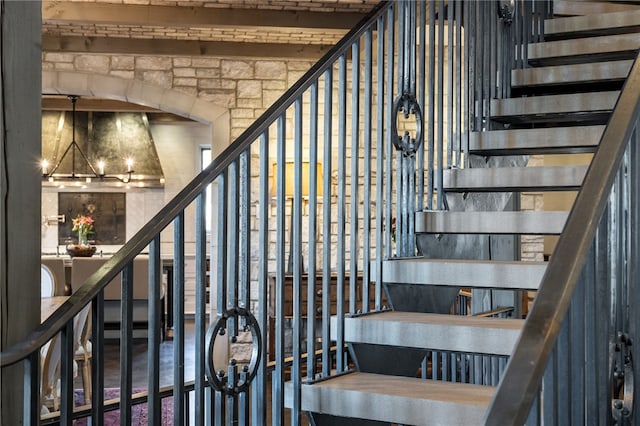 stairs with a chandelier