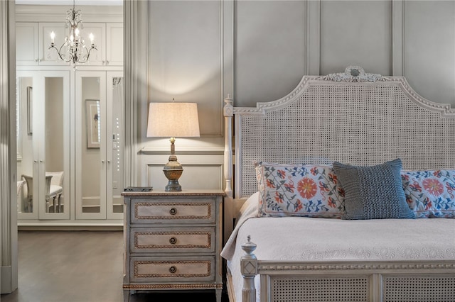 bedroom featuring a notable chandelier and concrete floors