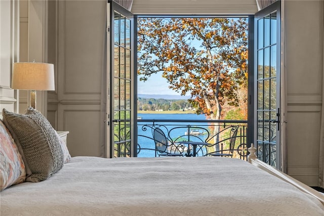 bedroom featuring a water view and access to outside