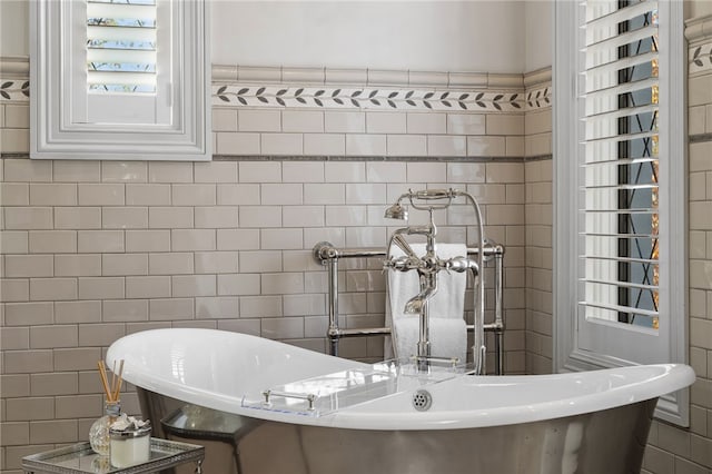 bathroom with a bathing tub and tile walls