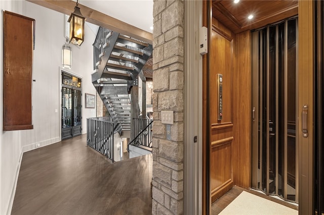 corridor featuring wood walls, wooden ceiling, dark wood-type flooring, and elevator