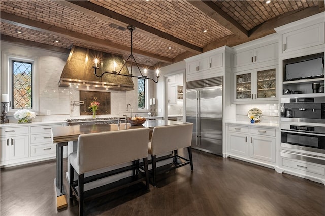 kitchen featuring white cabinetry, stainless steel appliances, and brick ceiling