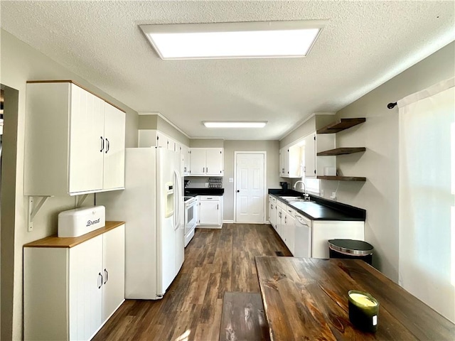 kitchen with sink, dark hardwood / wood-style flooring, a textured ceiling, white appliances, and white cabinets