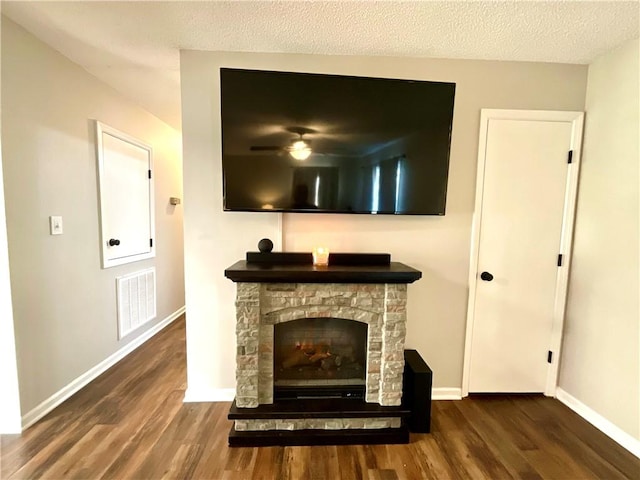 details featuring a stone fireplace, a textured ceiling, and hardwood / wood-style flooring