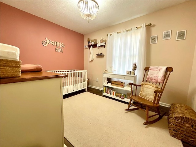 bedroom with radiator, a nursery area, and a textured ceiling