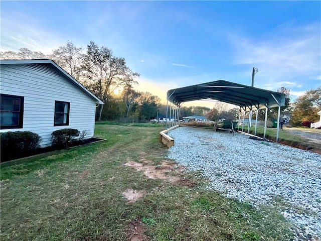 yard at dusk featuring a carport