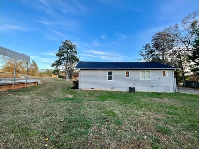 view of side of property with central AC and a yard