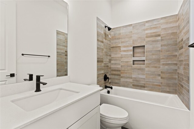 full bathroom featuring vanity, tiled shower / bath combo, and toilet