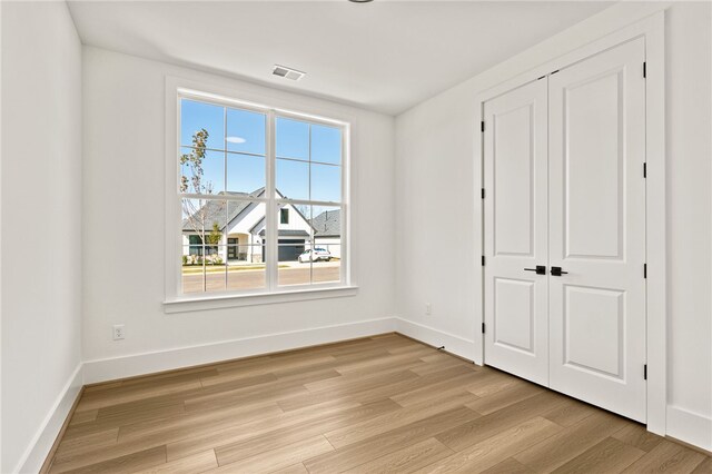 unfurnished bedroom featuring a closet and light hardwood / wood-style flooring