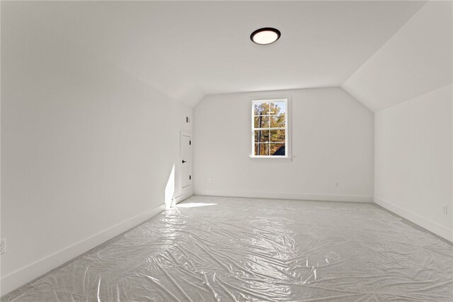 bonus room featuring light colored carpet and vaulted ceiling