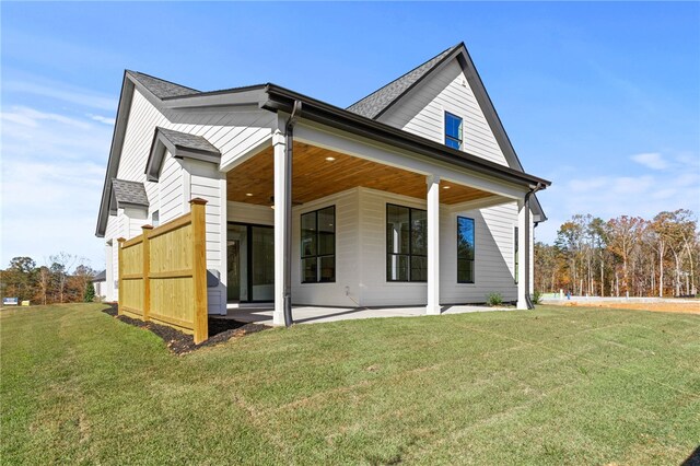 rear view of house with a patio area and a lawn