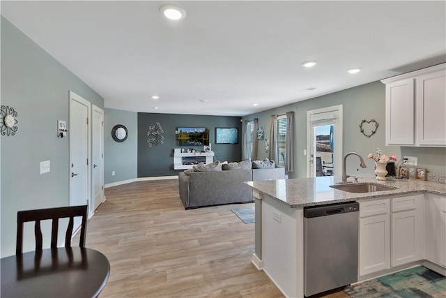 kitchen with white cabinetry, sink, stainless steel dishwasher, and light wood-type flooring