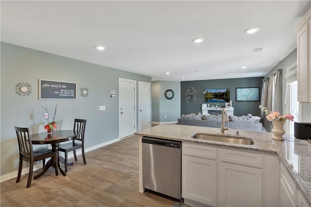 kitchen with dishwasher, white cabinets, sink, light hardwood / wood-style flooring, and light stone countertops