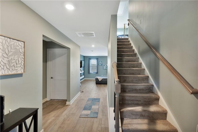 stairs featuring wood-type flooring