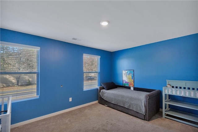 carpeted bedroom featuring multiple windows