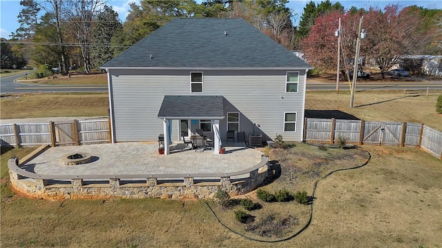 back of house featuring a yard, a fire pit, and a patio area