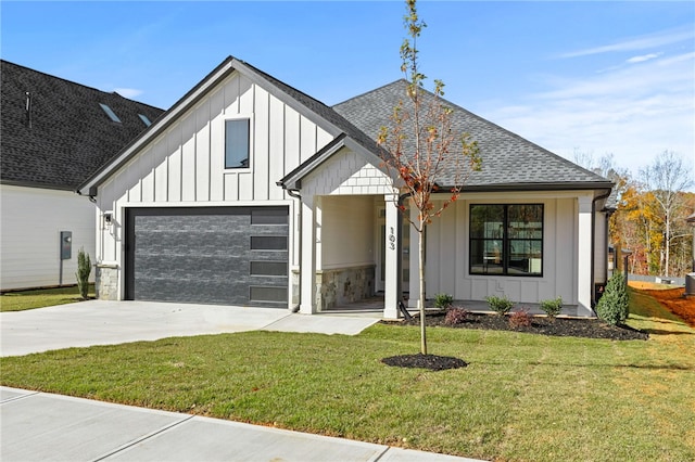 modern farmhouse featuring a front yard and a garage