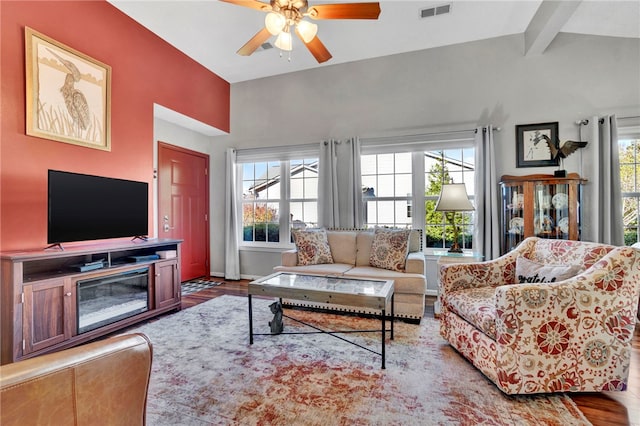 living room featuring hardwood / wood-style flooring, vaulted ceiling with beams, and ceiling fan