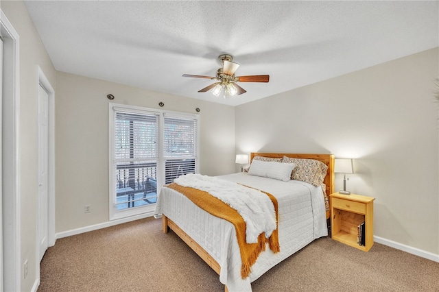 bedroom with ceiling fan, carpet, and a textured ceiling