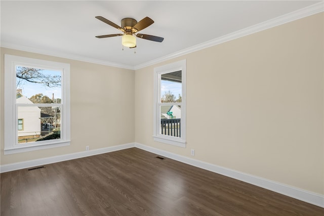 empty room featuring ceiling fan, a healthy amount of sunlight, dark hardwood / wood-style flooring, and crown molding