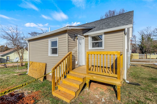 back of property with a yard and a wooden deck