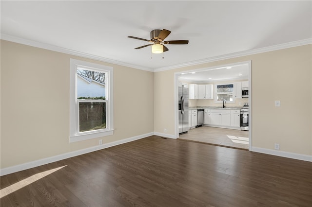 unfurnished living room featuring sink, ceiling fan, crown molding, and dark wood-type flooring