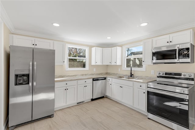 kitchen featuring white cabinets, ornamental molding, sink, and appliances with stainless steel finishes