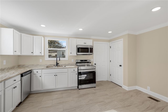 kitchen with white cabinetry, sink, light stone countertops, stainless steel appliances, and crown molding