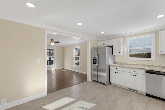 kitchen featuring stainless steel appliances, ceiling fan, crown molding, white cabinets, and light hardwood / wood-style floors