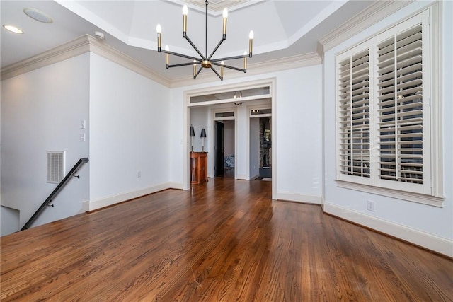 unfurnished living room with a tray ceiling, dark hardwood / wood-style flooring, a chandelier, and ornamental molding