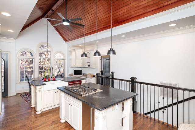 kitchen featuring pendant lighting, a kitchen island with sink, white cabinets, sink, and dark hardwood / wood-style floors