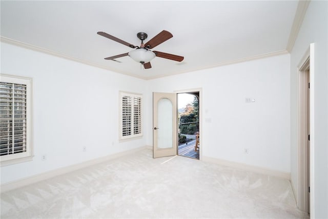 unfurnished room featuring light colored carpet, ceiling fan, and ornamental molding