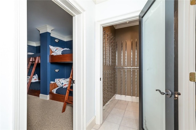 corridor with light tile patterned floors and crown molding