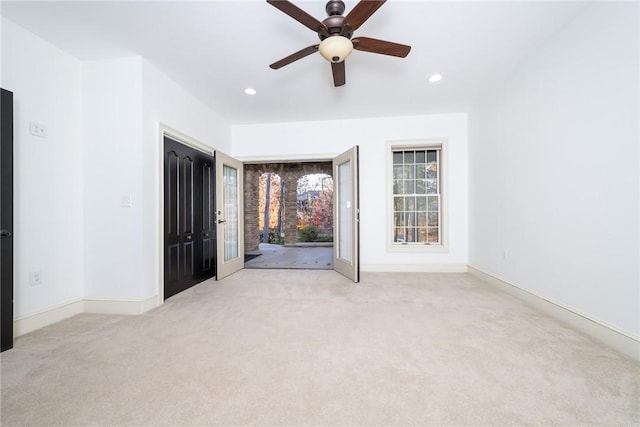 spare room featuring light carpet and ceiling fan