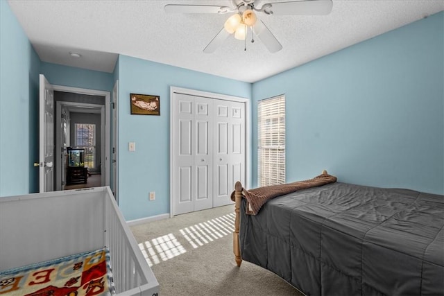 carpeted bedroom with a textured ceiling, a closet, and ceiling fan