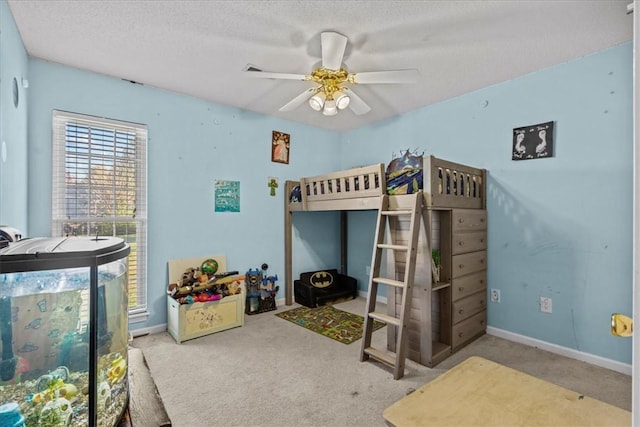 bedroom featuring ceiling fan, carpet floors, and a textured ceiling