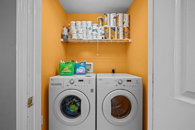 laundry room featuring a textured ceiling and washing machine and clothes dryer