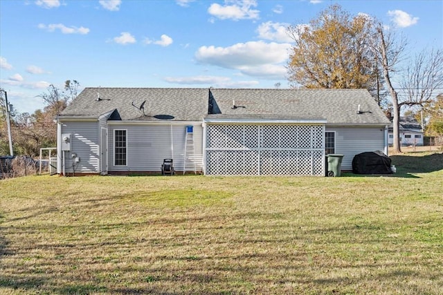 rear view of property featuring a lawn