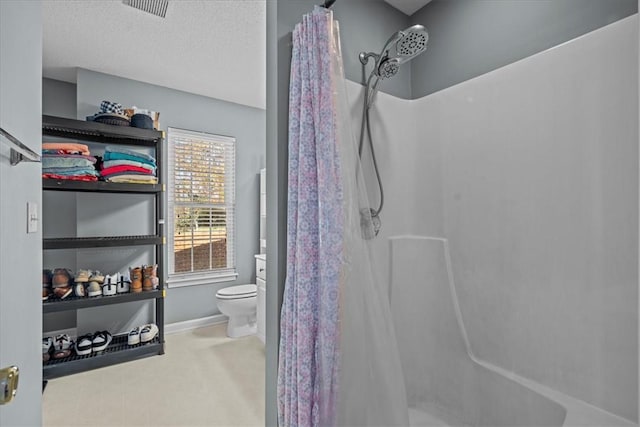 bathroom with vanity, a textured ceiling, toilet, and curtained shower