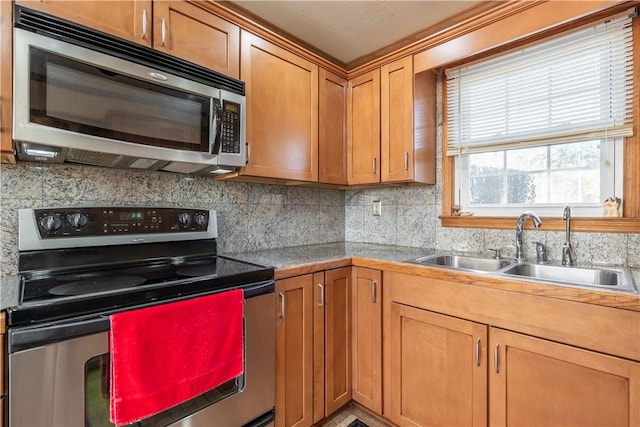 kitchen with backsplash, sink, a textured ceiling, and appliances with stainless steel finishes