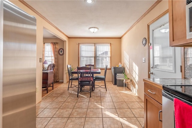 dining space with light tile patterned flooring and ornamental molding