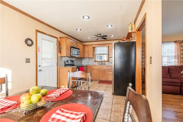 kitchen featuring backsplash, plenty of natural light, ornamental molding, and appliances with stainless steel finishes