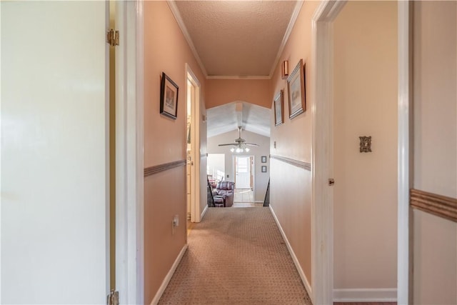 hallway featuring a textured ceiling, crown molding, carpet, and lofted ceiling