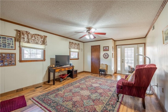 living room featuring hardwood / wood-style flooring, plenty of natural light, crown molding, and a textured ceiling