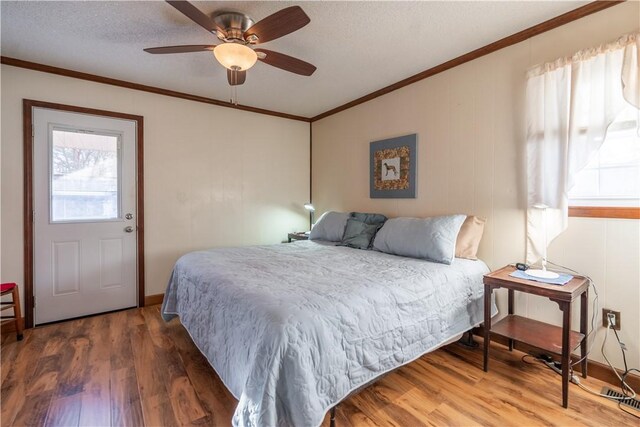 bedroom featuring a textured ceiling, dark hardwood / wood-style floors, ceiling fan, and crown molding