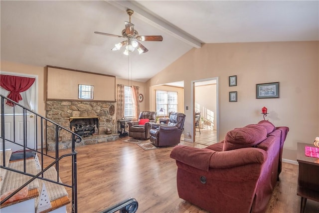 living room with hardwood / wood-style floors, lofted ceiling with beams, ceiling fan, and a fireplace