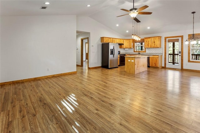 kitchen featuring hanging light fixtures, a center island, light hardwood / wood-style floors, and stainless steel refrigerator with ice dispenser