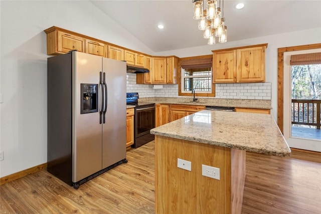 kitchen with light wood-type flooring, stainless steel appliances, pendant lighting, a center island, and lofted ceiling